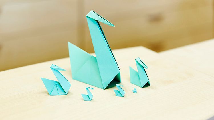 große und kleine Origami Schwäne aus grünem Papier